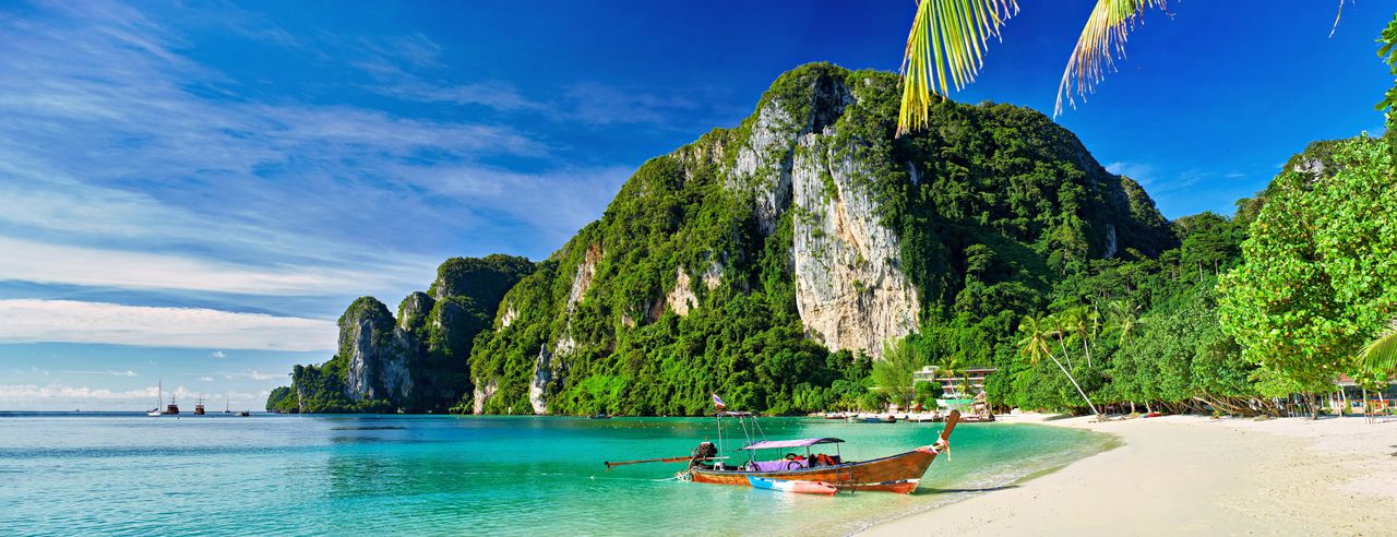 Bucht in Thailand mit Meer, Strand und Bergen sowie kleinem Boot