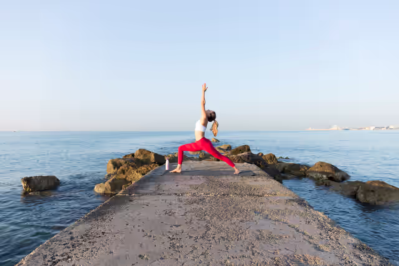 Frau die am Meer Yoga macht