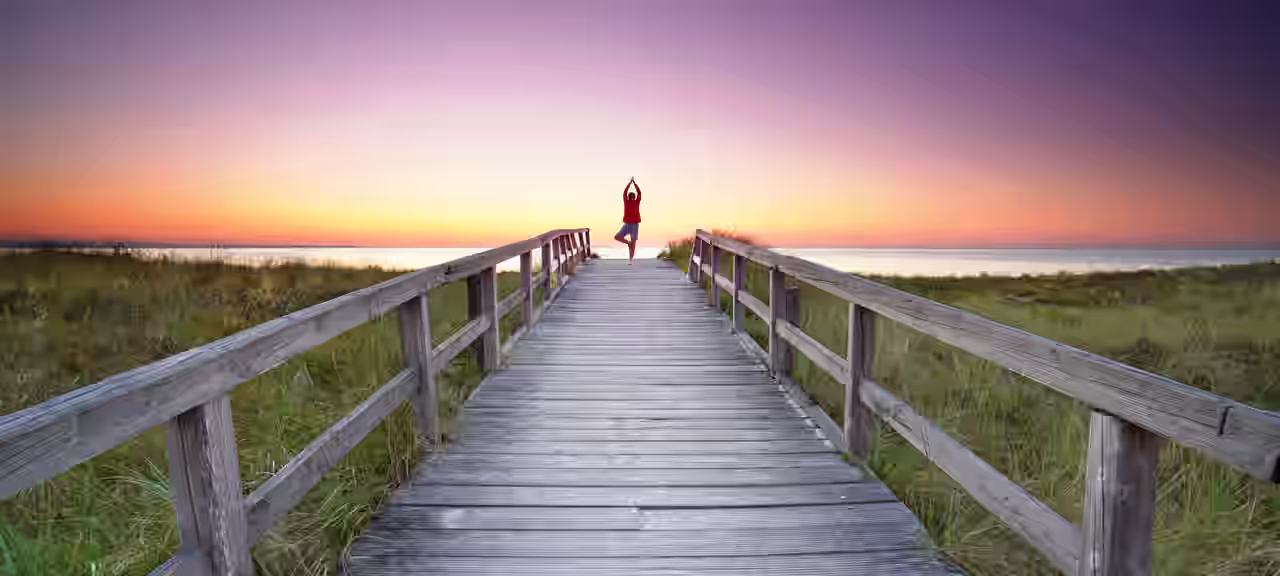 Eine Person übt ihre Yoga Asanas am Strand von Binz bei Sonnenaufgang