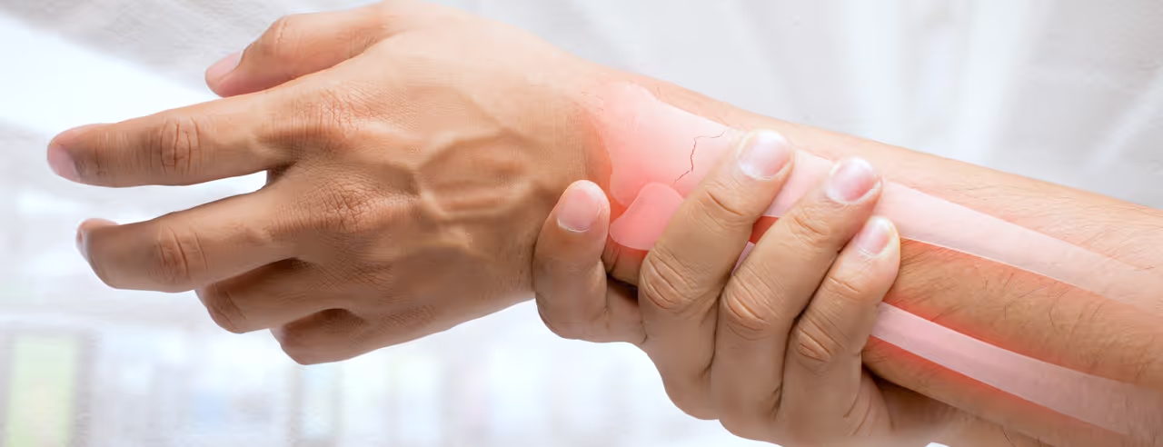 Eine Hand umfasst ein schmerzendes Handgelenk