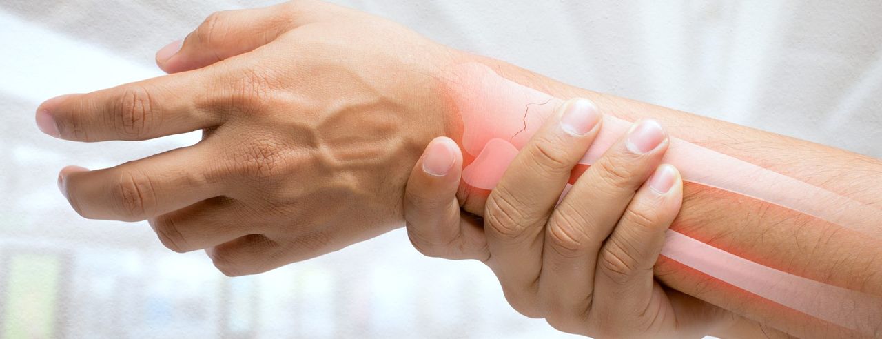 Eine Hand umfasst ein schmerzendes Handgelenk