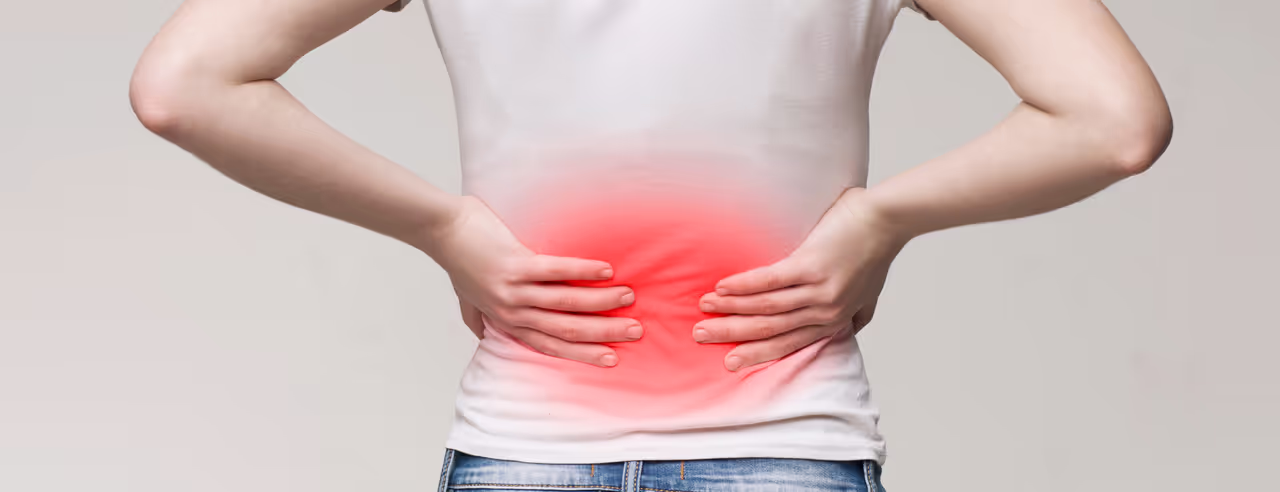 Personen håller sin värkande rygg