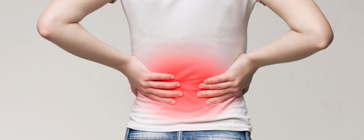 Person holds their aching back