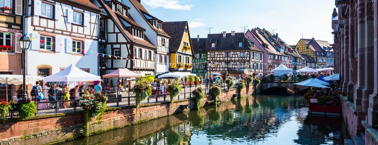 Das traumhafte Elsass mit Fachwerkhäusern vor einem Gewässer beim Bio Urlaub erleben