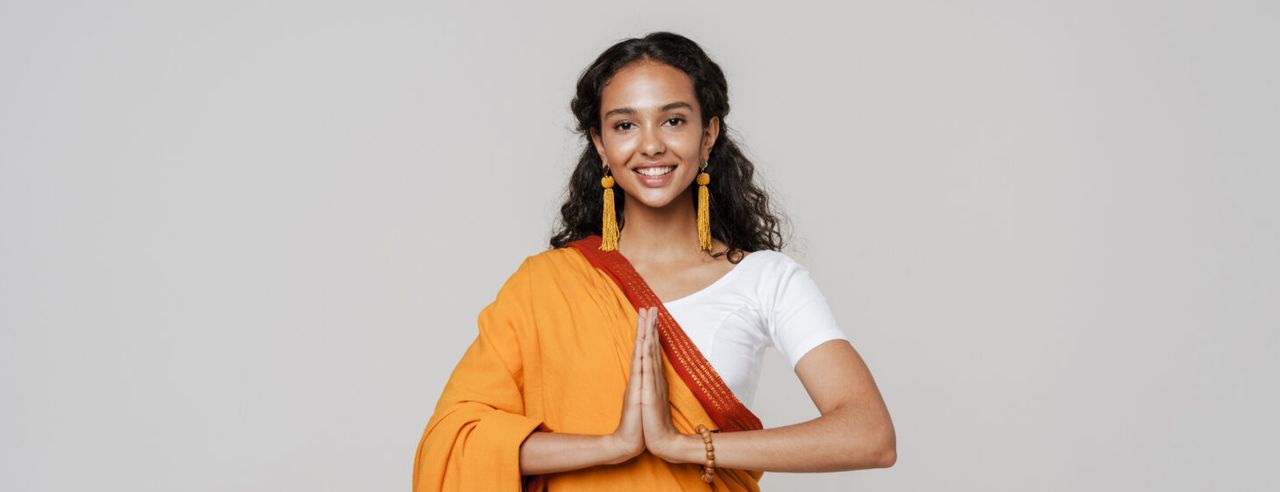 Indische Frau führt das Anjali Mudra aus beim Namaste