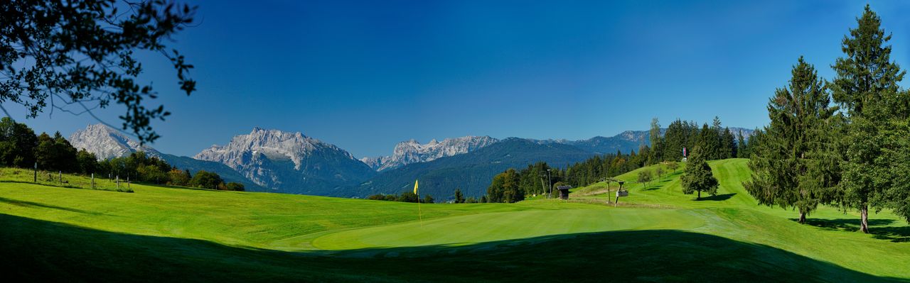 Golfplatz mit Bergen im Hintergrund
