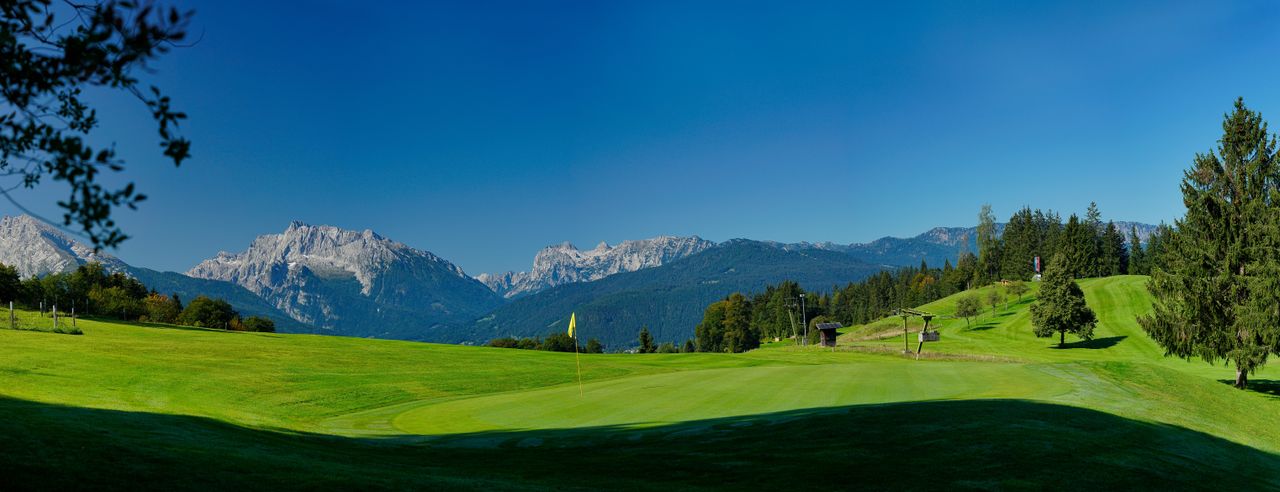 Golfplatz mit Bergen im Hintergrund