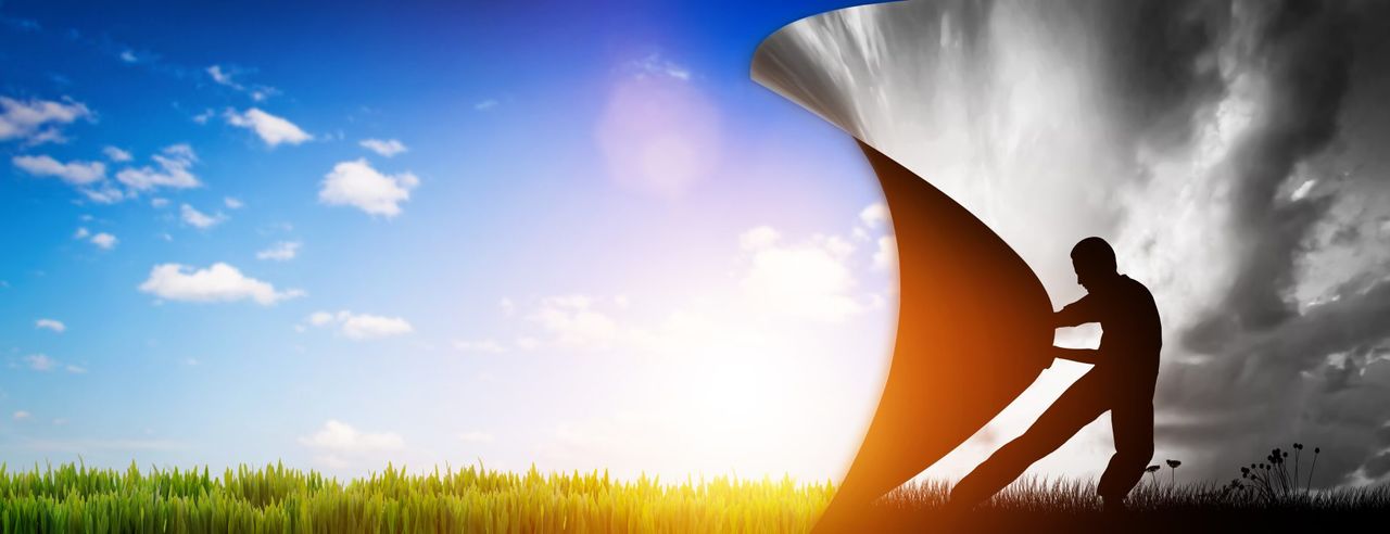 Silhouette eines Menschen zieht eine schwarz-weiße Schicht von einem farbenfrohen, sonnigen Naturbild