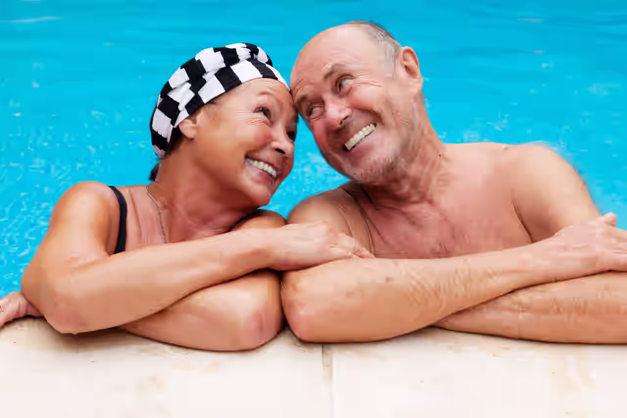Ein älteres Paar entspannt zusammen im Pool ihres Wellnesshotels für Erwachsene