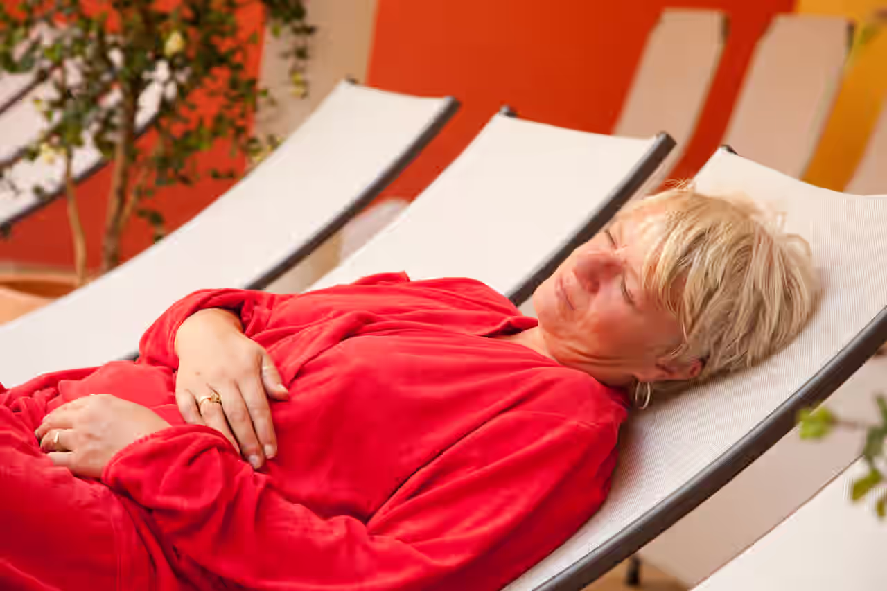 Eine Frau entspannt auf einer Liege im Wellnessbereich