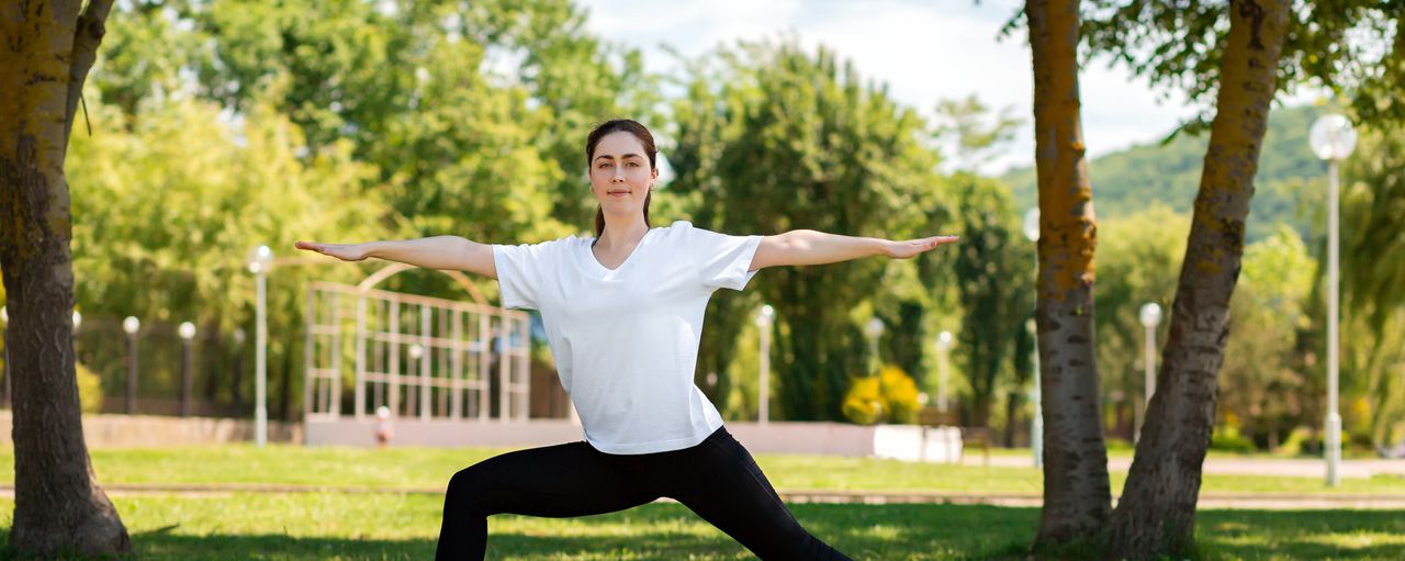 Eine Frau macht Yoga in einem Park