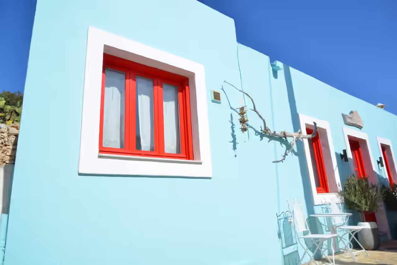 Blauer Bungalow mit roten Fensterrahmen