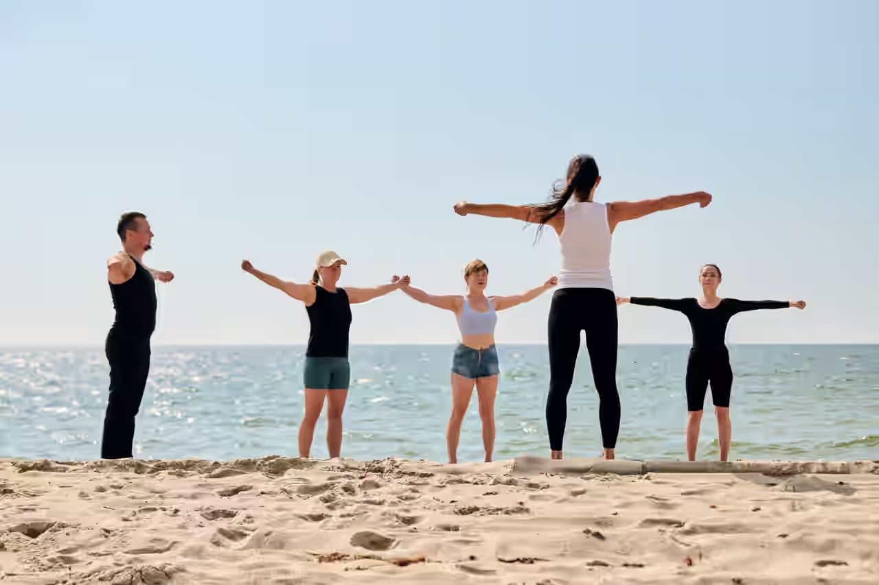 Gruppe macht Yoga Übungen am Strand