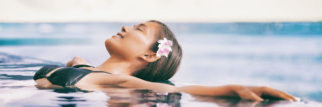 Frau im Infinity-Pool am Meer