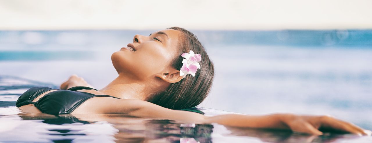 Frau im Infinity-Pool am Meer