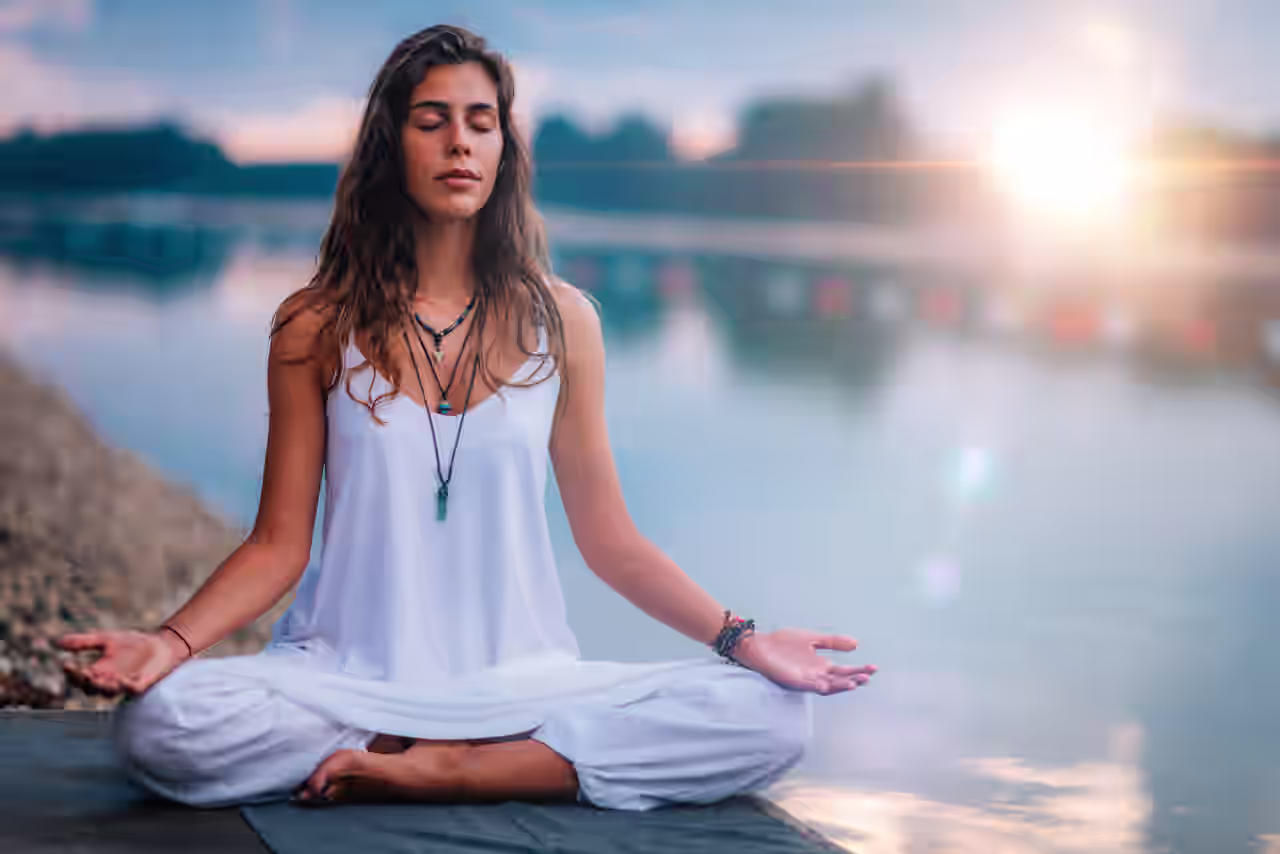 Eine Frau macht am See eine Meditation