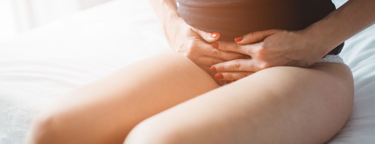 Una mujer se sujeta el abdomen dolorido