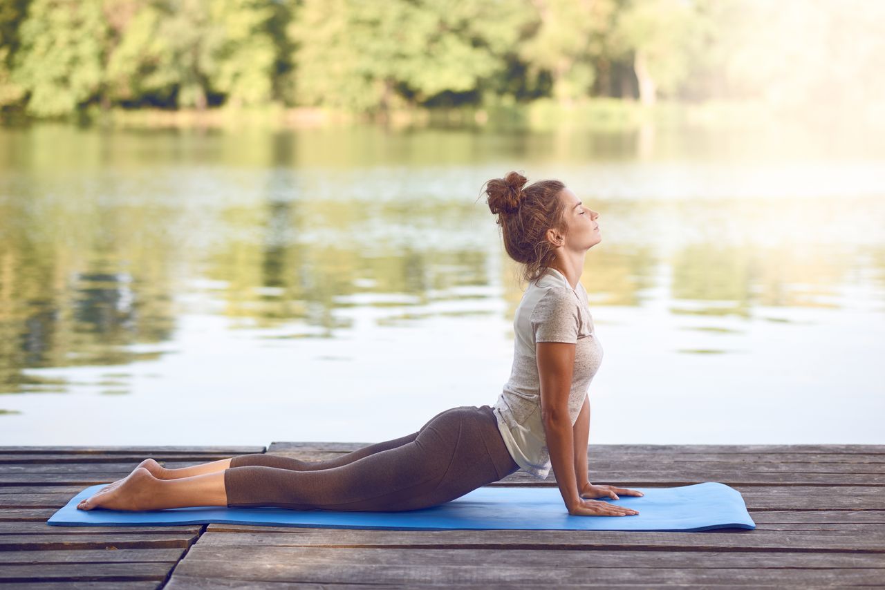 Frau macht Yoga am See in Brandenburg