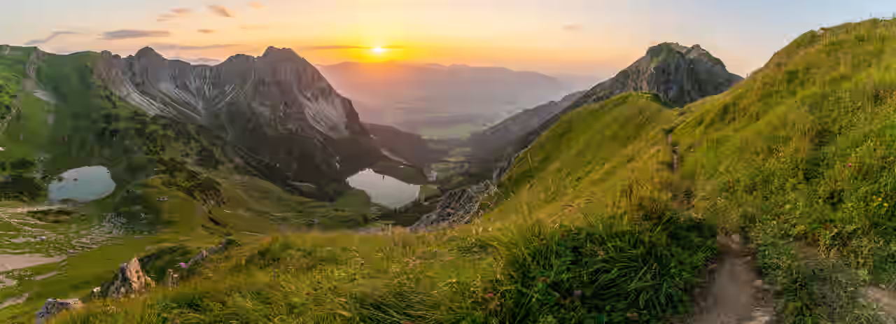 Allgäu Panorama mit zwei Seen zwischen grünen Bergen bei Sonnenuntergang