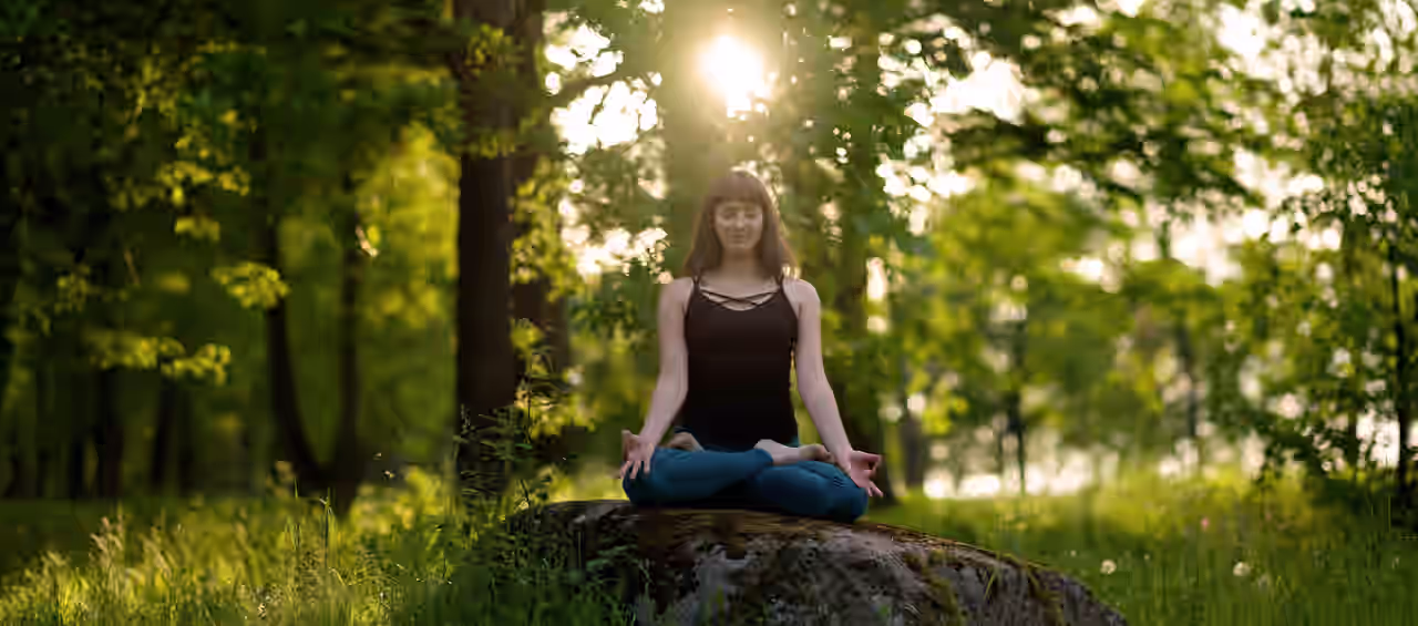 Eine Frau meditiert im Wald