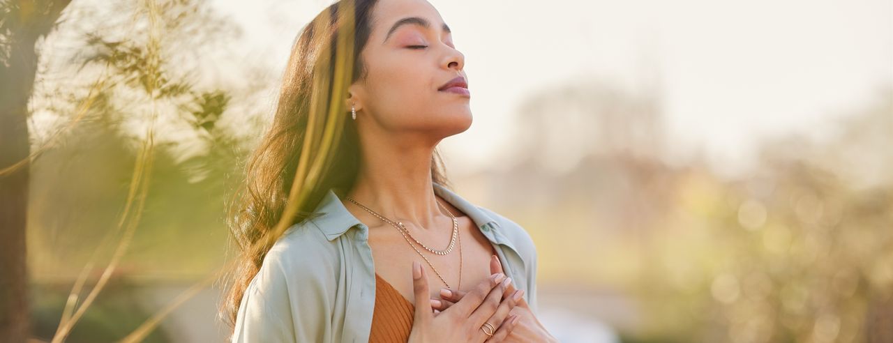 Eine Frau atmet tief durch bei Ihrer Meditation bei chronisch obstruktiver Lungenerkrankung