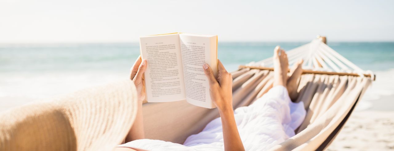 Een vrouw leest een boek in een hangmat