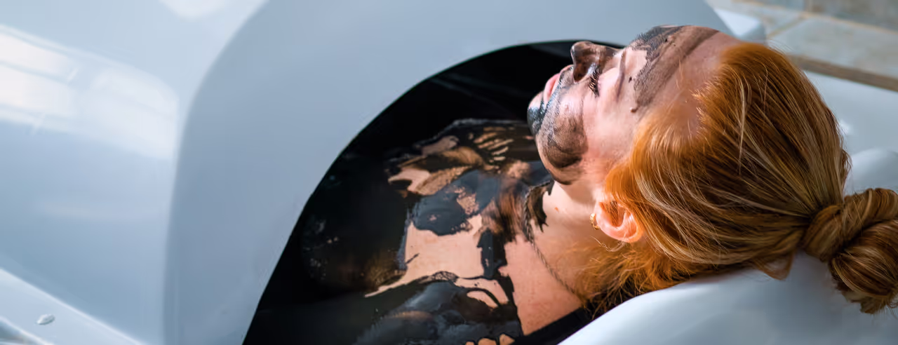 Una donna sdraiata in un bagno di fango