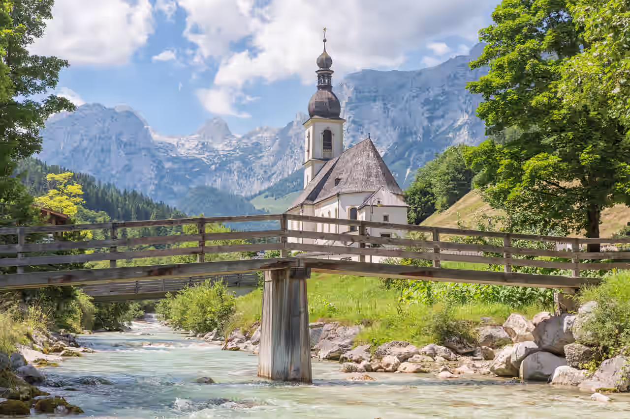 Kleine Kirche hinter Brücke. neben Fluss im Wald