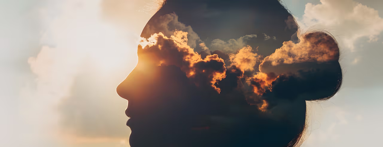 Une image artistique de la tête d'une femme, avec un ciel nuageux représenté dans sa tête, pour symboliser le fait que la méditation a un impact sur la substance cérébrale.