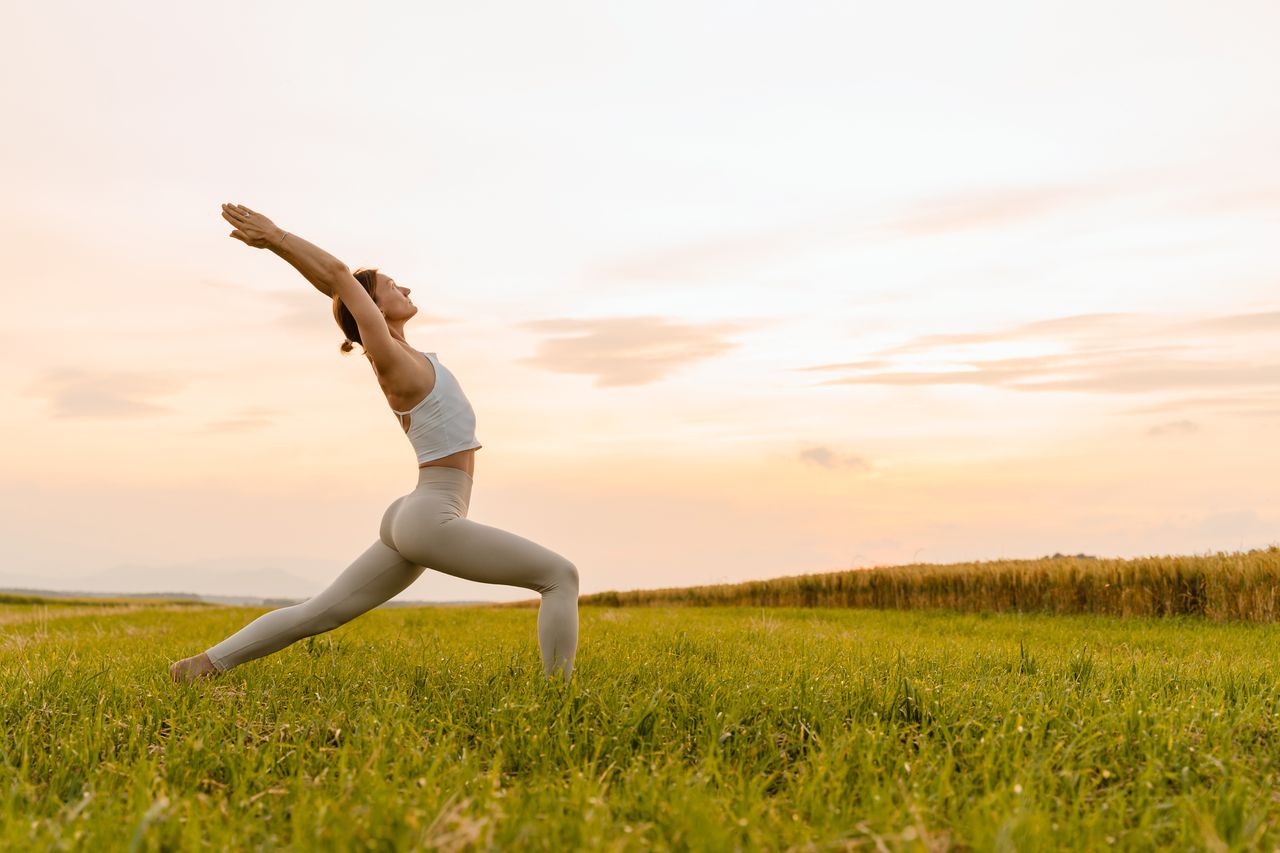 Eine Frau praktiziert Yoga in der schönen Umgebung vom Sauerland bei ihrer Yoga Auszeit.