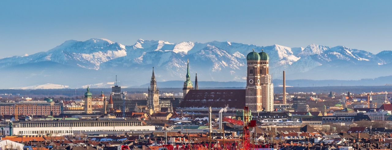 Skyline von München mit Alpenbergen im Hintergrund