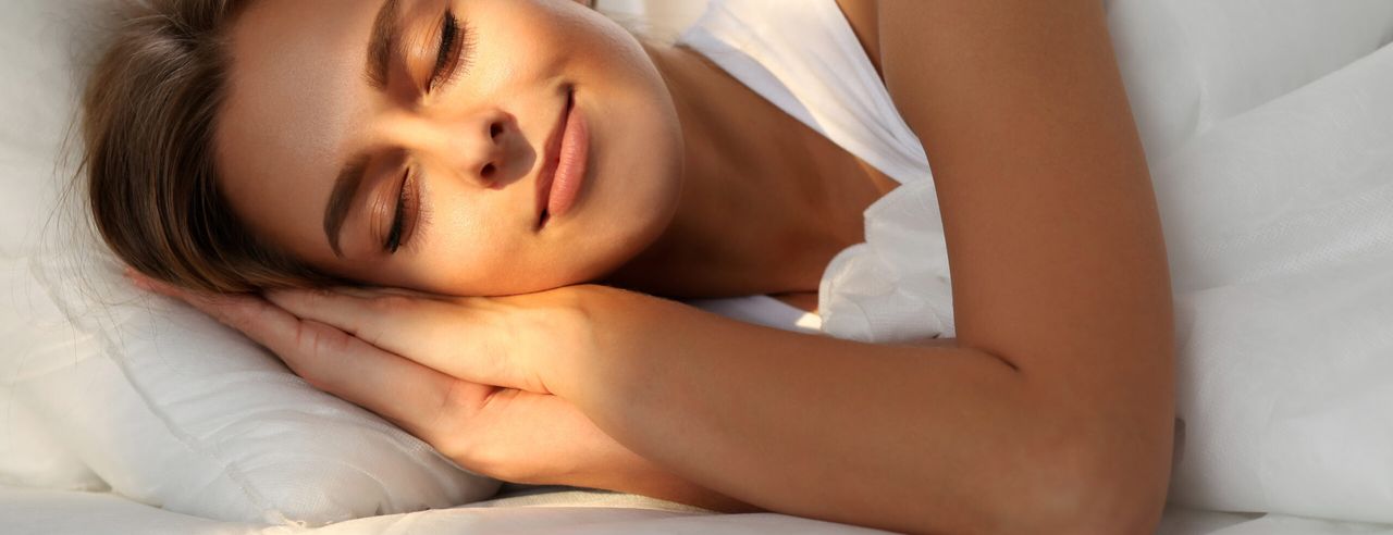 Eine schlafende Frau mit Sonnenstrahlen im Gesicht