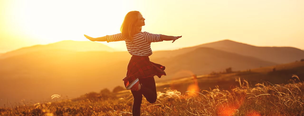 Frau im Sonnenlicht vor bergiger Kulisse
