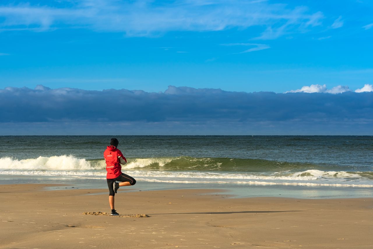 Eine Person macht Yoga am Strand der Nordsee