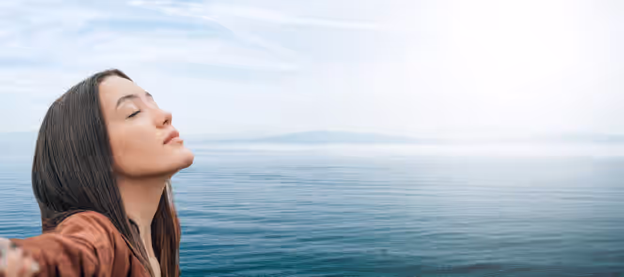 Ein Mädchen atmet entspannt im Freien mit dem Meer im Hintergrund