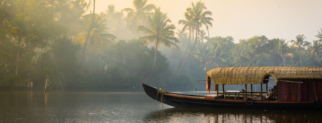 Ein traditionelles Hausboot ankert am Ufer eines Sees in Kerala