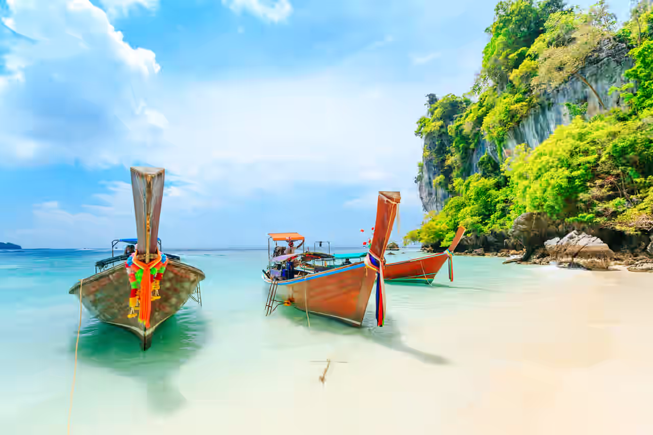 Meeresküste mit Felsen und Booten auf blauem Wasser in Thailand