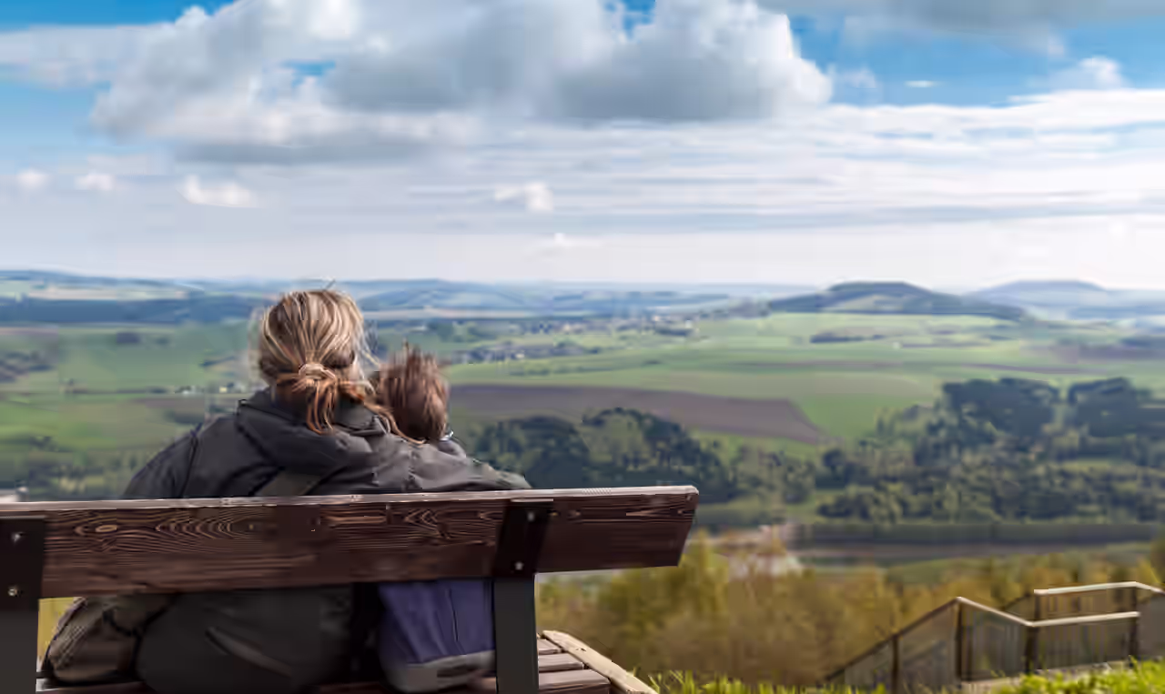 Mutter und Kind auf einer Bank mit Panoramablick über die Landschaft des Erzgebirges