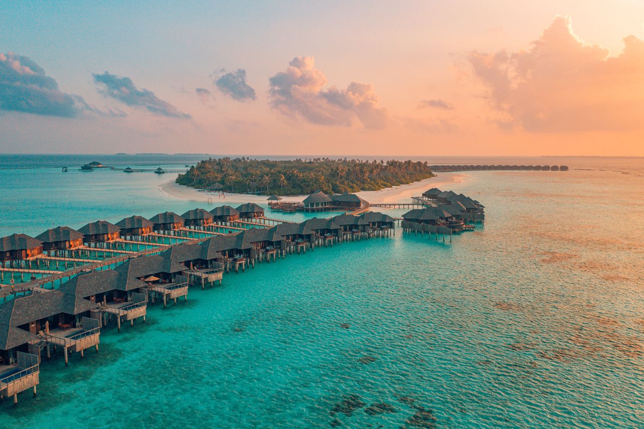 Bungalows im Meer bei Sonnenuntergang