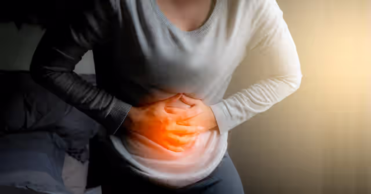 Eine Frau hält sich den schmerzenden Bauch, weil Sie einen Reizdarm hat