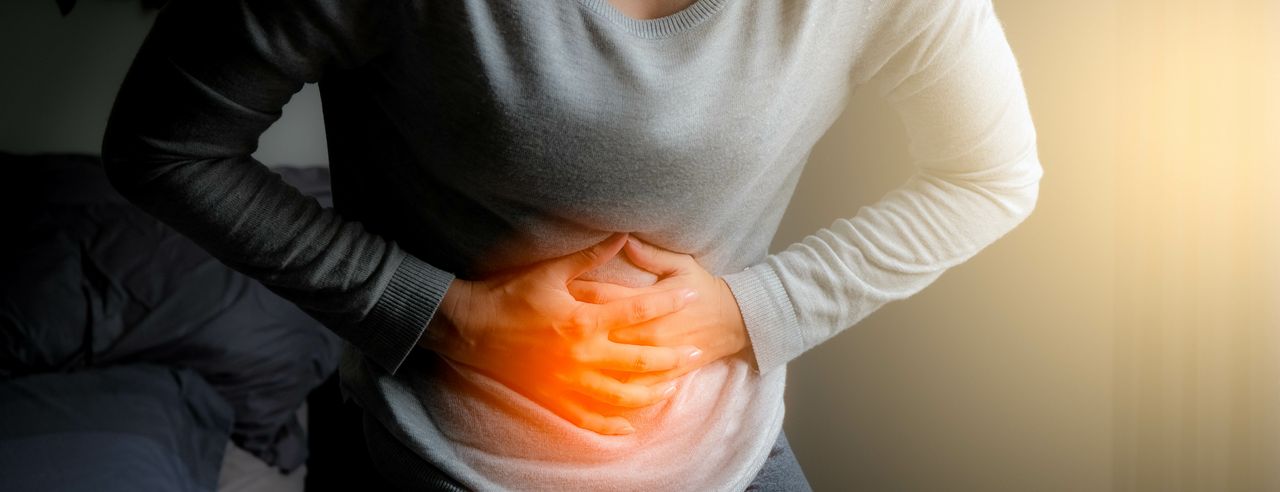 Eine Frau hält sich den schmerzenden Bauch, weil Sie einen Reizdarm hat