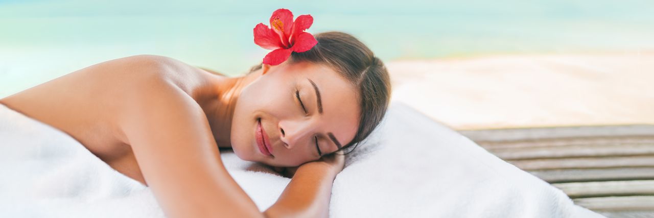 Eine Frau liegt entspannt auf dem Bauch und bekommt eine Rückenmassage