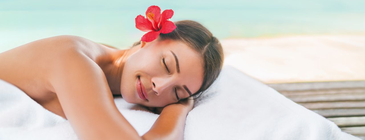 Eine Frau liegt entspannt auf dem Bauch und bekommt eine Rückenmassage