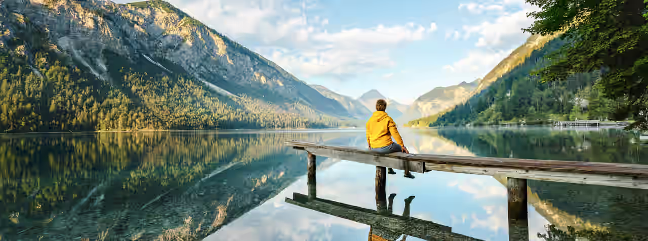 Ein Mann auf einem Holzsteg am Bergsee