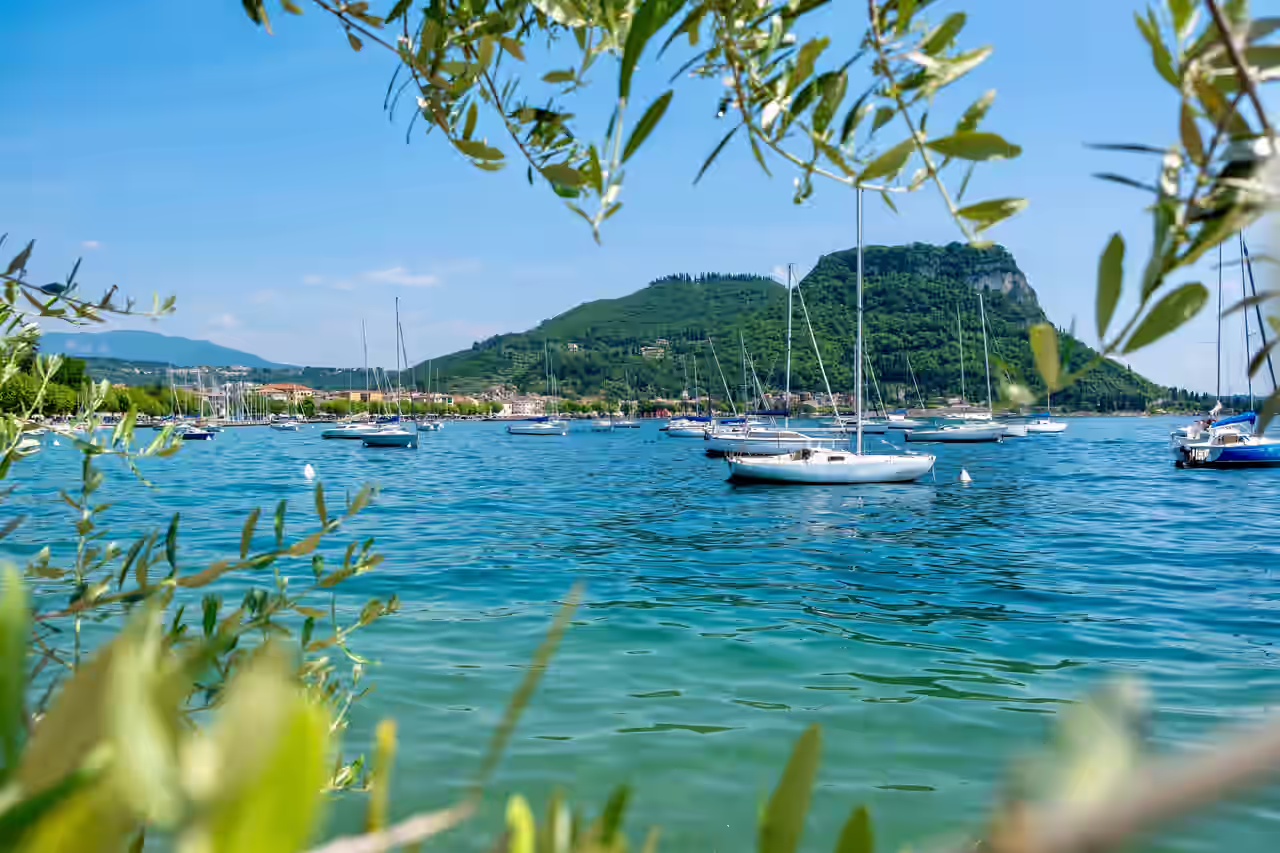 Ausblick auf den Gardasee mit Segelboten und Bergen im Hintergrund
