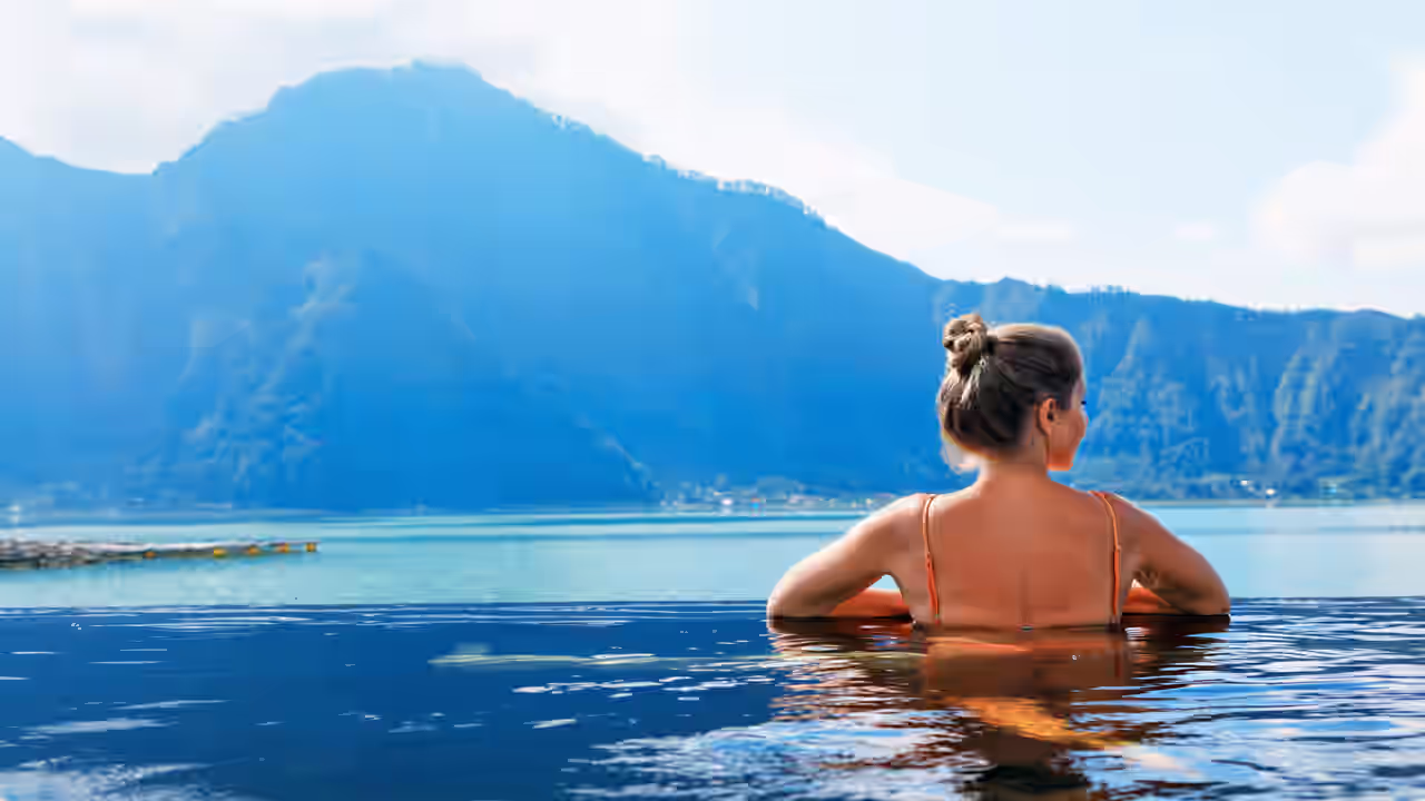 Frau entspannt im Pool mit Blick auf die Berge