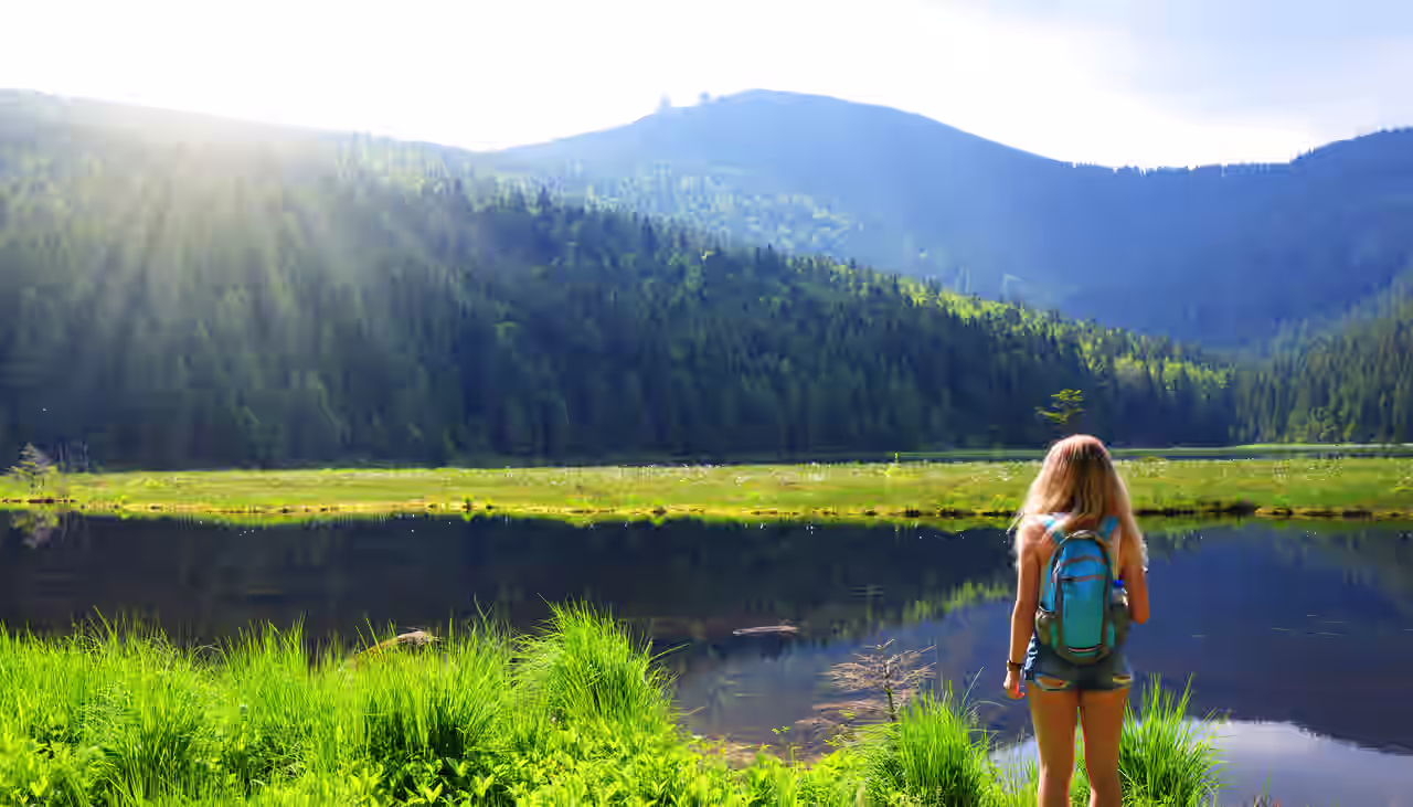 Eine Frau wandert am Kleinen Arbersee im Bayerischen Wald