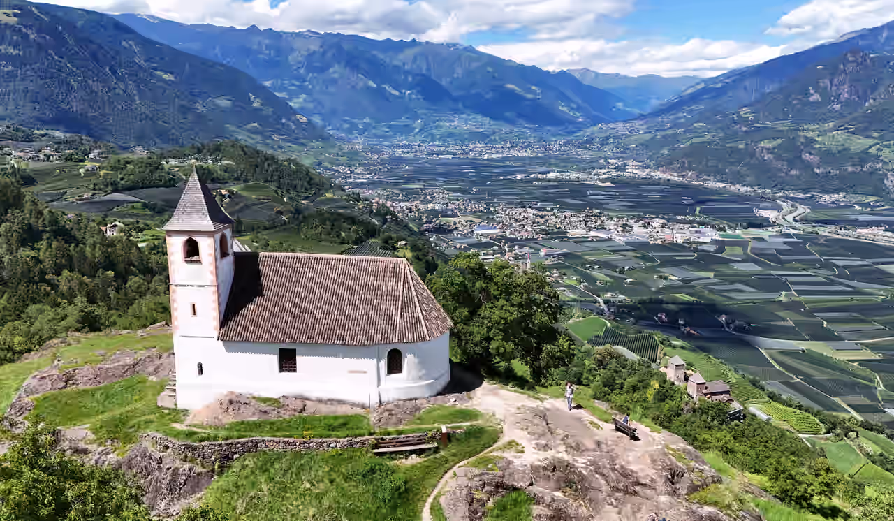 Weiße Kirche auf einem Berg oberhalb von Lana in Südtirol