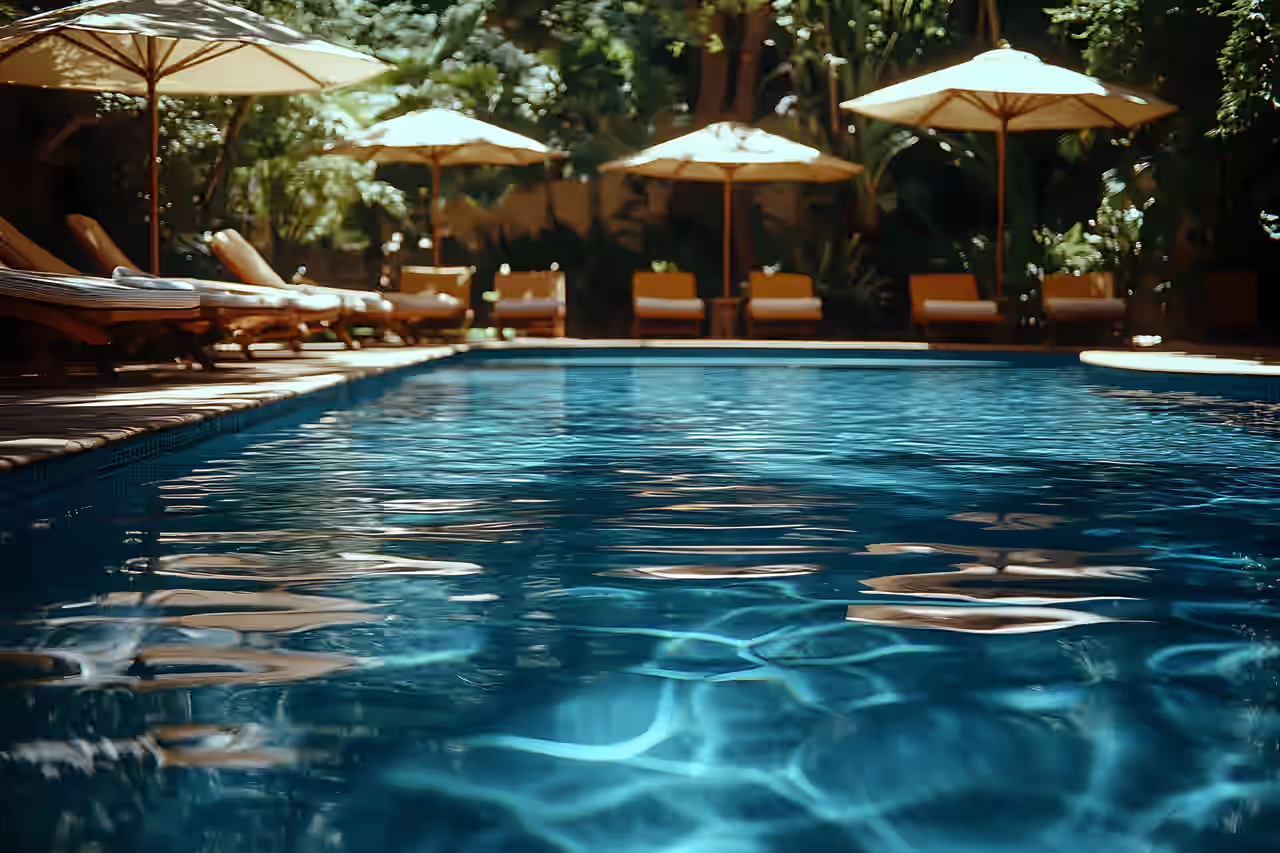 Außenpool mit Liegen und Sonnenschirmen