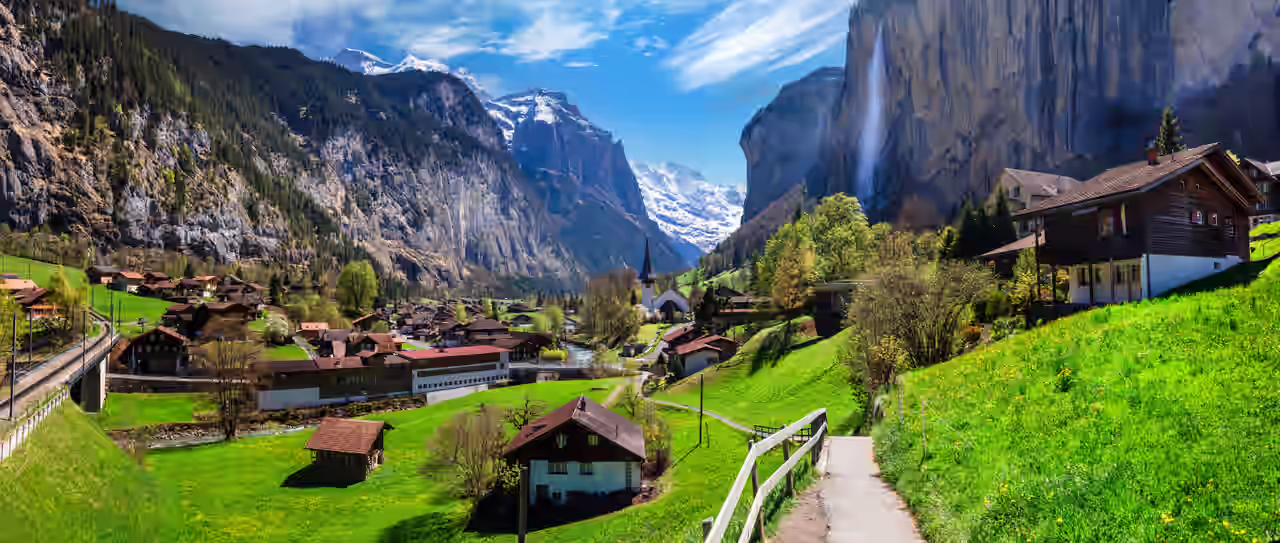 Ein idyllisches Dorf umring von hohen Bergen in der Schweiz